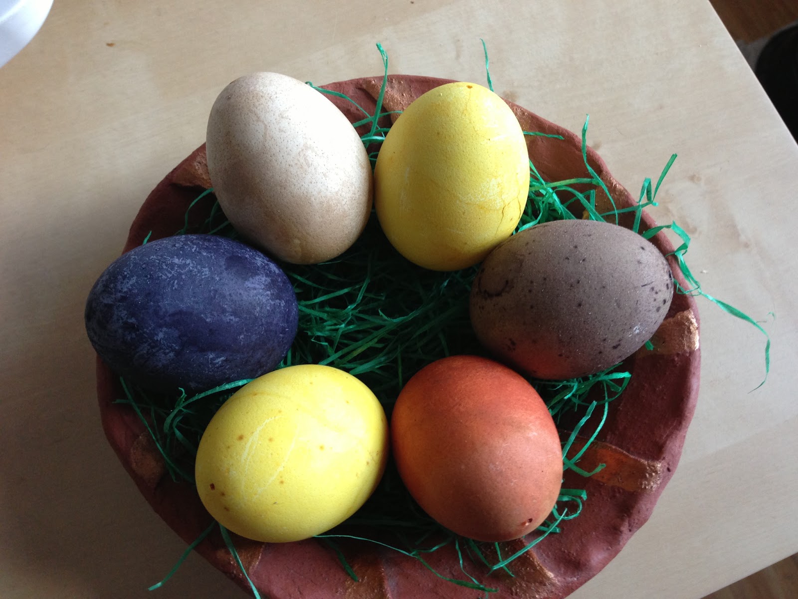 Eggs dyeing in natural color . Clockwise from the top right we have turmeric (yellow), red wine (purple-ish), onion skin (brick red), another turmeric, blue berry (dark blue), and last and kind of least: paprika powder.